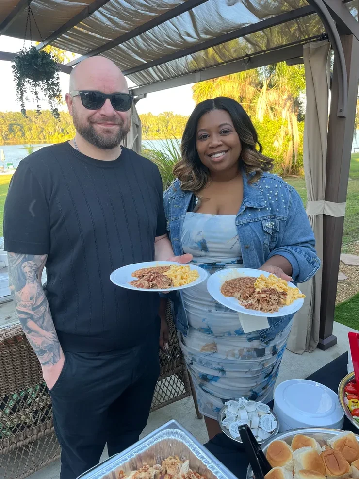 Couple serving food at outdoor gathering