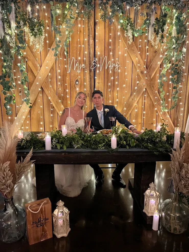 Mr and Mrs barn wedding sweetheart table with candles and lanterns