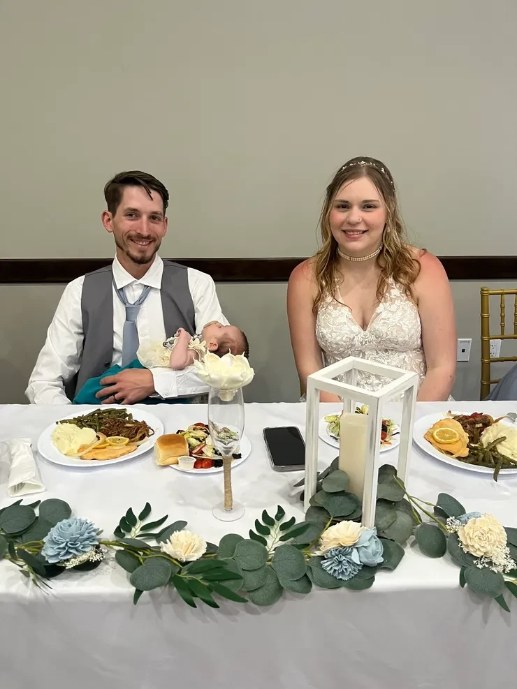 Newlyweds at wedding reception dinner table