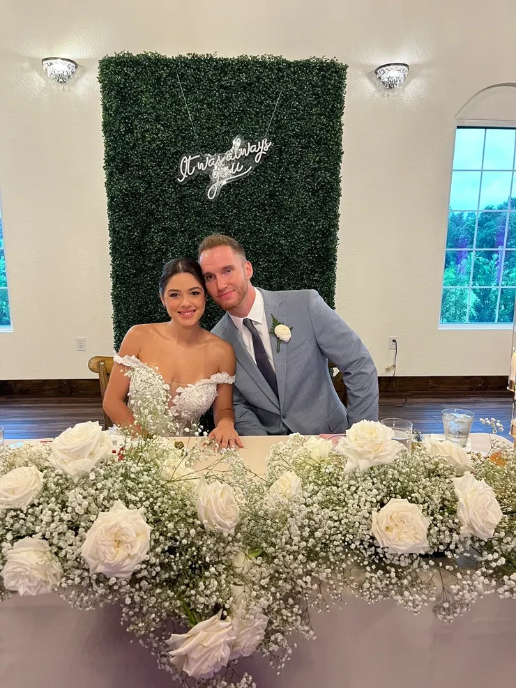 Bride and groom posing at wedding reception table